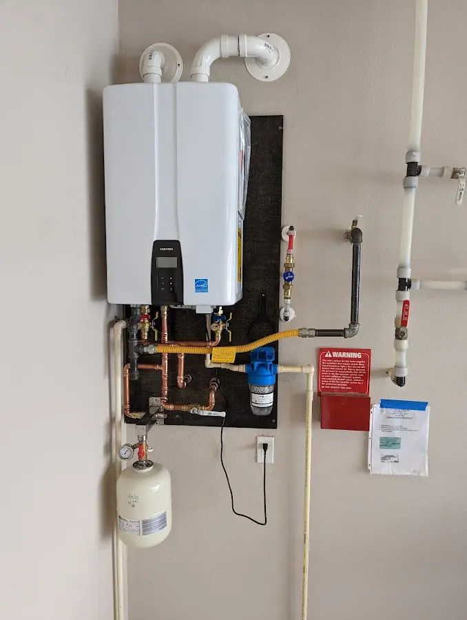 Professional plumber installing copper piping in a Tipton home